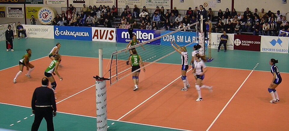 Partido de vóley femenino en un coliseo lleno