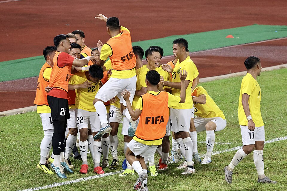 Hinchas celebrando en un coliseo durante un partido de vóley
